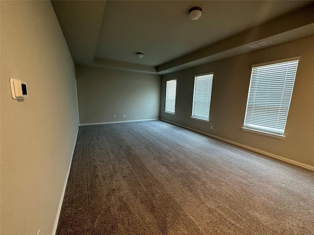 unfurnished room with carpet, baseboards, and a tray ceiling