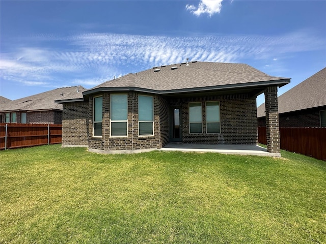 rear view of house with a patio area, brick siding, and a shingled roof