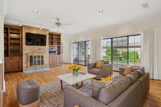 1817 Crockett Cir, Irving, TX 75038 - living room featuring ornamental molding, ceiling fan, a fireplace, recessed lighting, and light wood finished floors