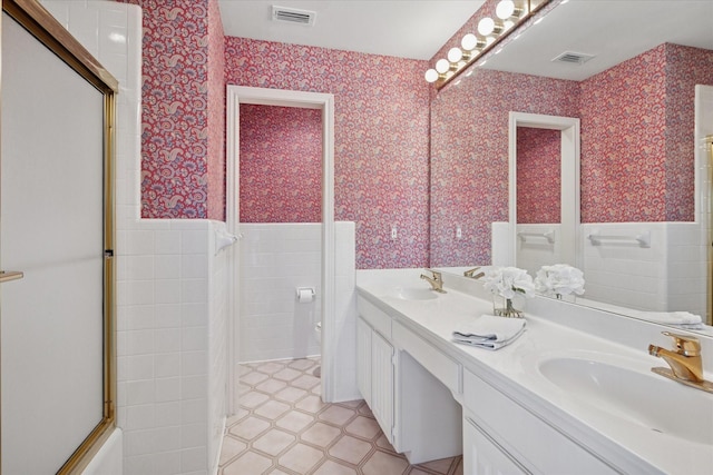 1817 Crockett Cir, Irving, TX 75038 - bathroom with tile patterned floors, double vanity, tile walls, a shower with door, and toilet