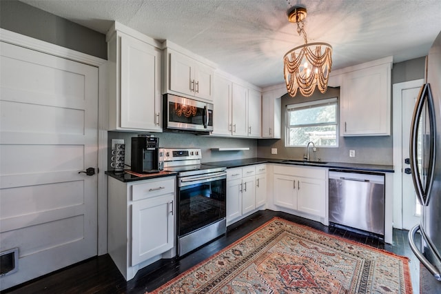 2420 N Carroll Blvd, Denton, TX 76201 - kitchen featuring appliances with stainless steel finishes, a sink, a chandelier, dark countertops, and a textured ceiling