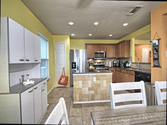8614 Mountain Blf, Dallas, TX 75227 - kitchen with stainless steel appliances, dark countertops, a sink, a center island, and recessed lighting