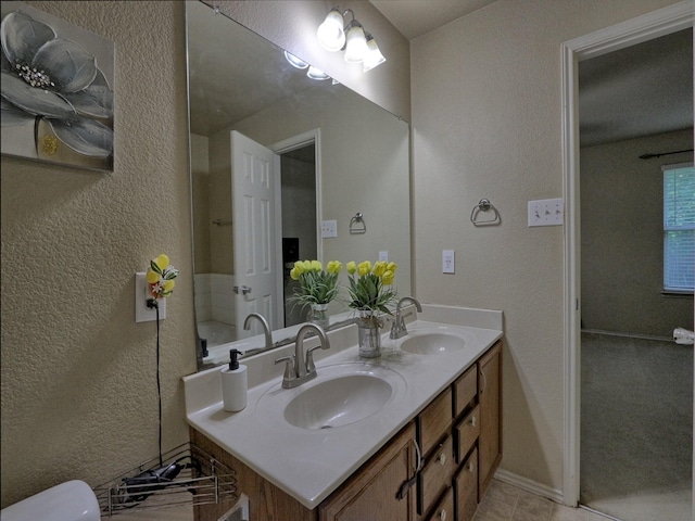 8614 Mountain Blf, Dallas, TX 75227 - full bathroom with a textured wall, double vanity, toilet, baseboards, and tile patterned flooring