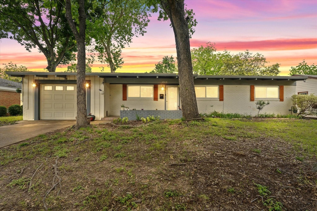 1909 Bunker Hill Dr, Irving, TX 75061 - view of front of property featuring a garage, brick siding, driveway, and board and batten siding