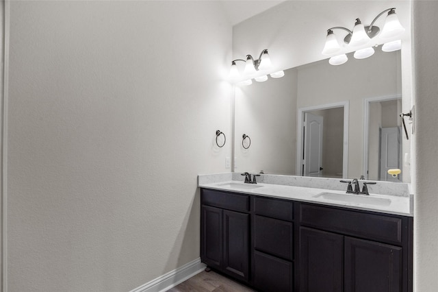 7500 W Fork Ln, Mckinney, TX 75071 - bathroom featuring double vanity, wood finished floors, and baseboards