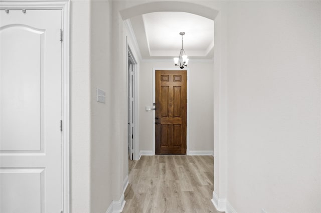 7500 W Fork Ln, Mckinney, TX 75071 - hallway with arched walkways, light wood-style floors, baseboards, a raised ceiling, and crown molding