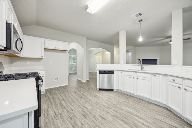 549 Seminole Trl, Murphy, TX 75094 - kitchen featuring stainless steel appliances, a sink, arched walkways, a textured ceiling, and white cabinets