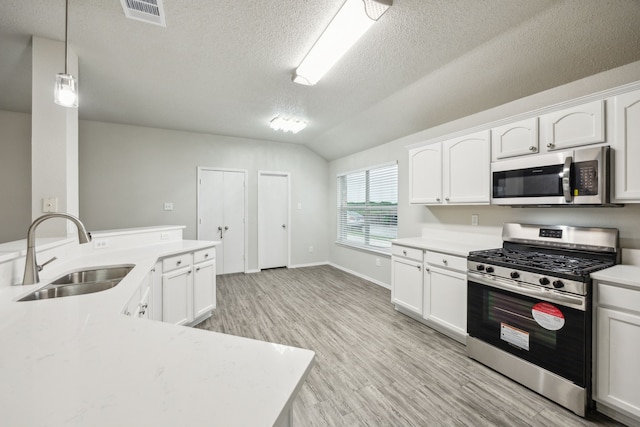 549 Seminole Trl, Murphy, TX 75094 - kitchen with appliances with stainless steel finishes, a sink, light wood-style floors, light countertops, and a textured ceiling