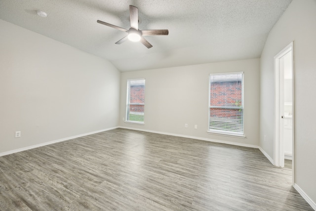 549 Seminole Trl, Murphy, TX 75094 - unfurnished room with ceiling fan, wood finished floors, a textured ceiling, lofted ceiling, and baseboards