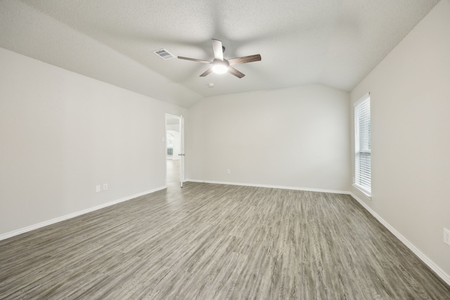 549 Seminole Trl, Murphy, TX 75094 - unfurnished room with a ceiling fan, wood finished floors, baseboards, lofted ceiling, and a textured ceiling