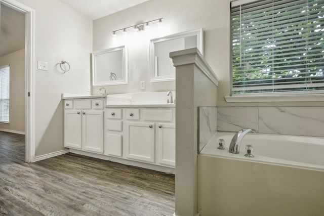 549 Seminole Trl, Murphy, TX 75094 - bathroom with plenty of natural light, double vanity, a garden tub, and wood finished floors