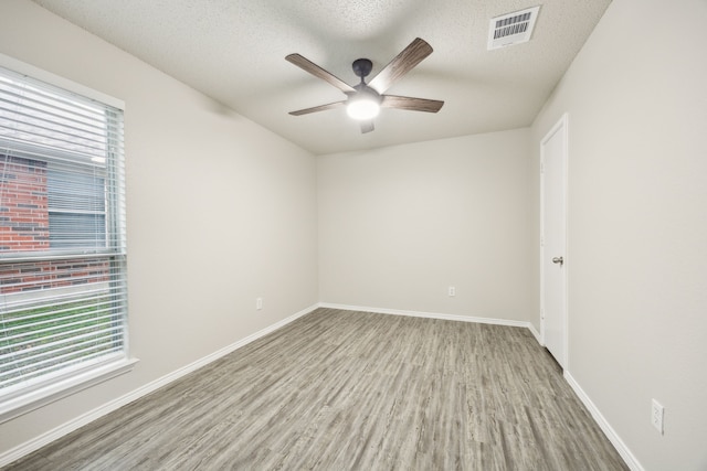 549 Seminole Trl, Murphy, TX 75094 - spare room featuring wood finished floors, a ceiling fan, baseboards, and a textured ceiling
