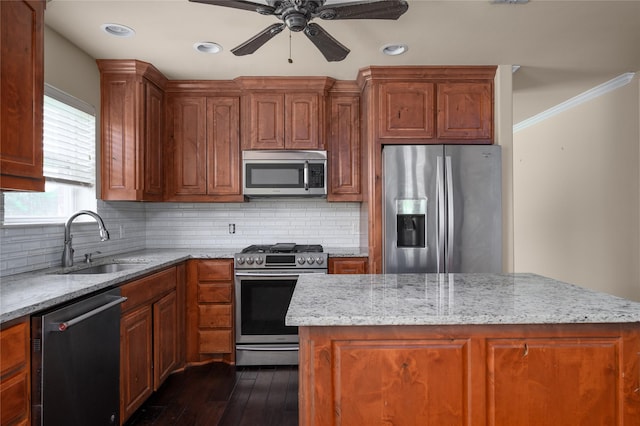 1443 Teal, Sherman, TX 75092 - kitchen featuring appliances with stainless steel finishes, a sink, ceiling fan, backsplash, and light stone countertops