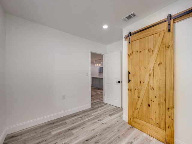 224 High St, Roxton, TX 75477 - empty room featuring light wood finished floors, a barn door, baseboards, and recessed lighting