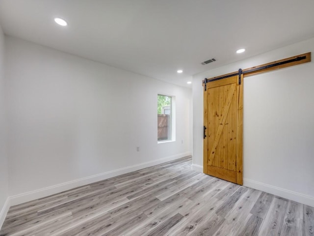 224 High St, Roxton, TX 75477 - unfurnished room featuring light wood finished floors, a barn door, recessed lighting, and baseboards