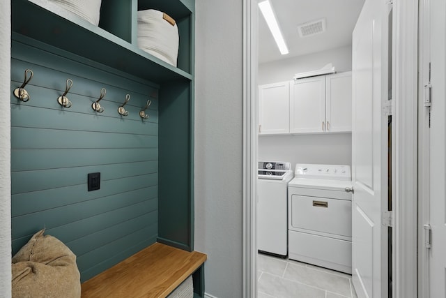 laundry room with cabinet space, washing machine and clothes dryer, and light tile patterned flooring