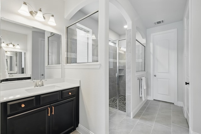 bathroom with a stall shower, tile patterned flooring, vanity, and baseboards