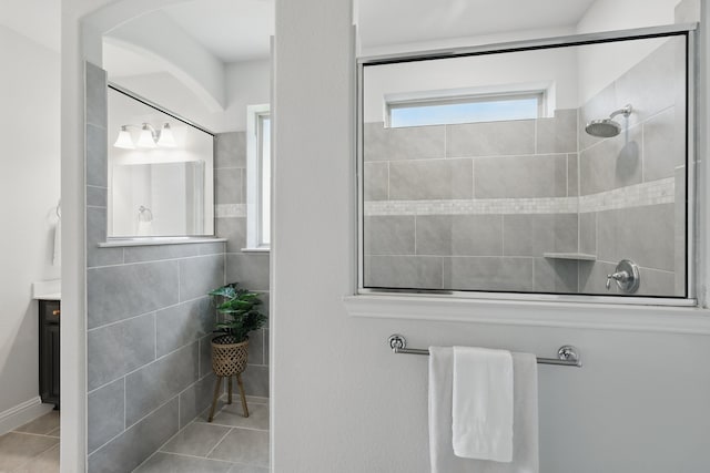 full bathroom with a walk in shower, vanity, and tile patterned flooring