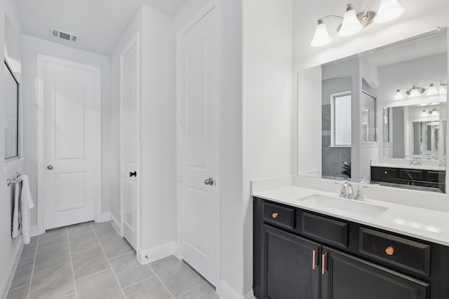 full bath with tile patterned floors, baseboards, and two vanities