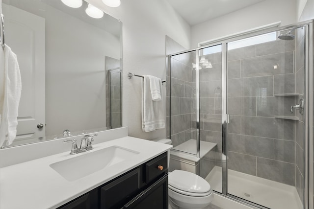 full bathroom with a shower stall, toilet, and vanity