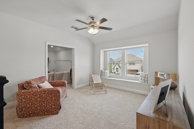 living area with ceiling fan, carpet floors, baseboards, and lofted ceiling