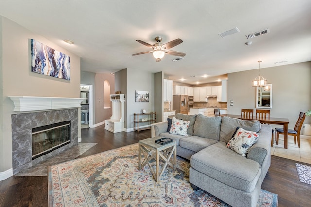 3625 Cottonwood Springs Dr, The Colony, TX 75056 - living area featuring baseboards, ceiling fan, dark wood finished floors, a tiled fireplace, and a chandelier