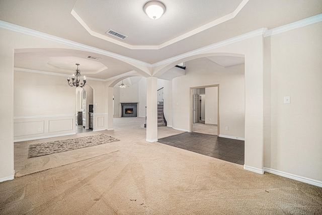 1432 Fence Post Dr, Fort Worth, TX 76052 - unfurnished living room featuring a tray ceiling, arched walkways, carpet, a chandelier, and stairs