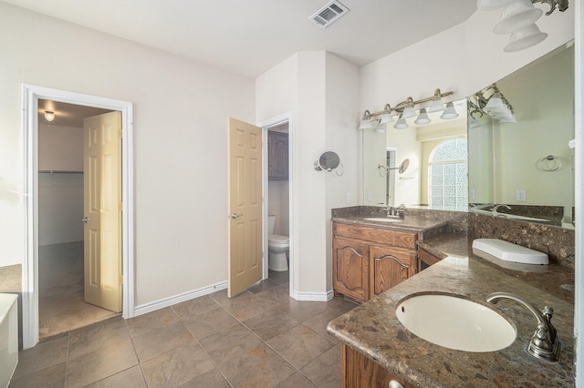 1432 Fence Post Dr, Fort Worth, TX 76052 - bathroom featuring toilet, double vanity, a spacious closet, and baseboards
