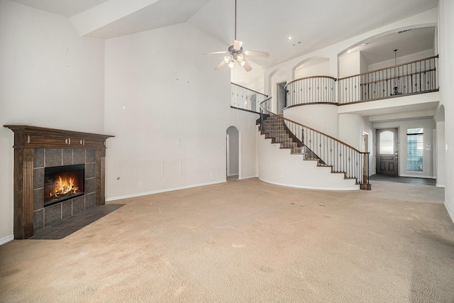 1432 Fence Post Dr, Fort Worth, TX 76052 - unfurnished living room with carpet, high vaulted ceiling, a tile fireplace, stairs, and a ceiling fan
