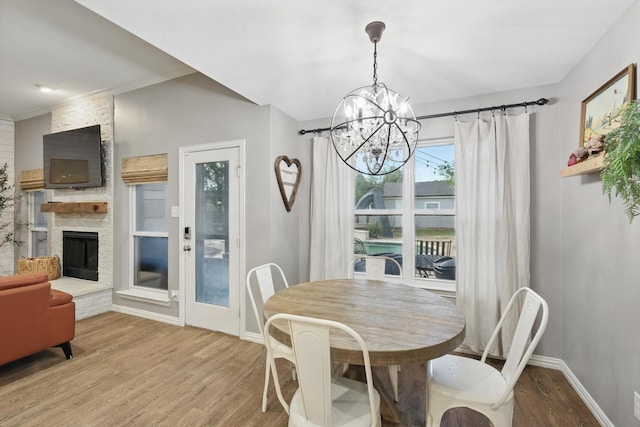 104 Radecke Rd, Krum, TX 76249 - dining area with a chandelier, wood finished floors, baseboards, and a fireplace