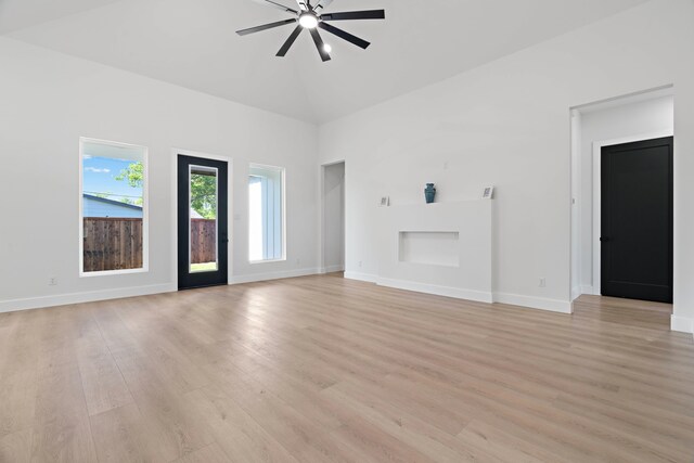 205 Altamesa Blvd, Fort Worth, TX 76134 - unfurnished living room featuring a ceiling fan, light wood-style floors, baseboards, a towering ceiling, and a fireplace