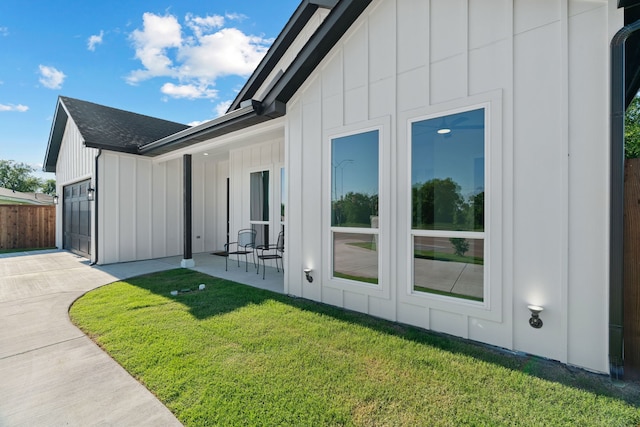 205 Altamesa Blvd, Fort Worth, TX 76134 - view of home's exterior with board and batten siding, a garage, a yard, concrete driveway, and a shingled roof