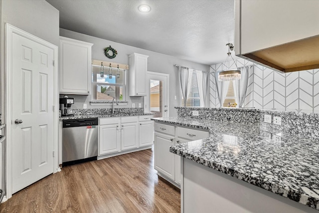 1505 Oakcrest Dr, Providence Village, TX 76227 - kitchen featuring dishwasher, light wood finished floors, white cabinetry, dark stone countertops, and a sink