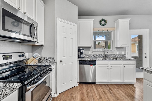 1505 Oakcrest Dr, Providence Village, TX 76227 - kitchen with appliances with stainless steel finishes, a sink, light wood finished floors, and white cabinetry
