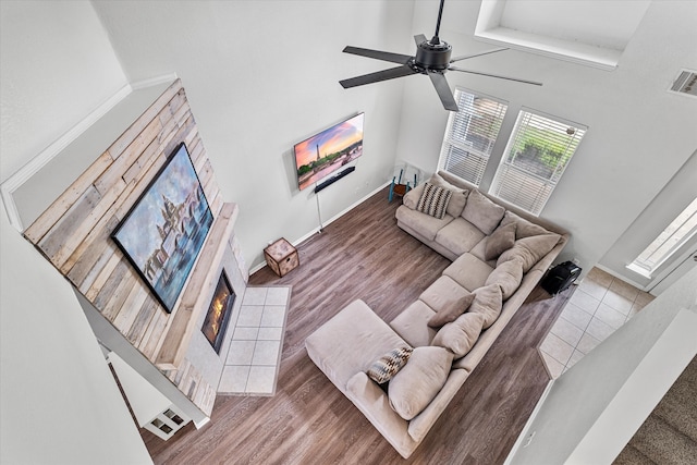 1505 Oakcrest Dr, Providence Village, TX 76227 - living area featuring a tiled fireplace, ceiling fan, baseboards, and a towering ceiling