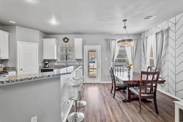 1505 Oakcrest Dr, Providence Village, TX 76227 - kitchen featuring light stone counters, dark wood-style floors, white cabinets, a chandelier, and baseboards