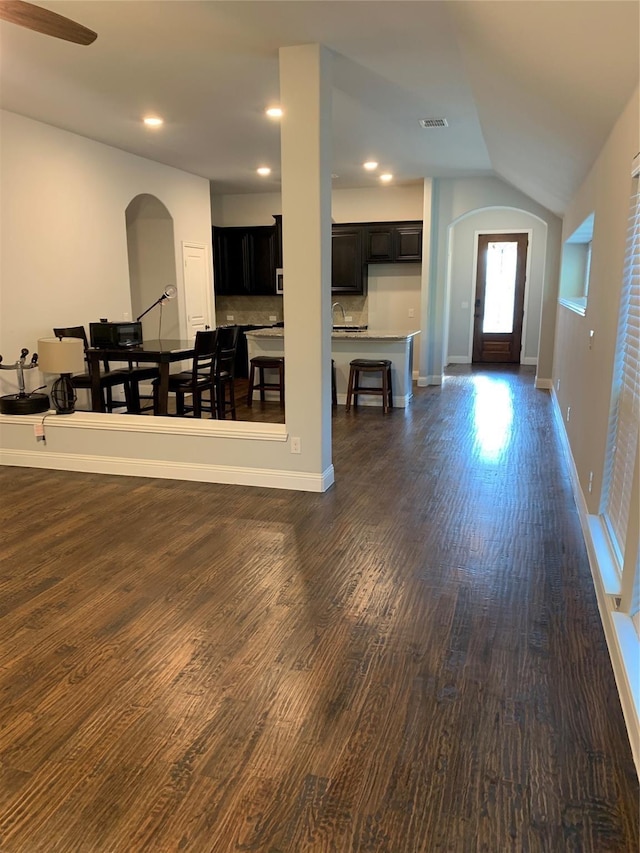 1609 Emerald Tree Pl, Aubrey, TX 76227 - living room featuring arched walkways, vaulted ceiling, dark wood-type flooring, baseboards, and recessed lighting