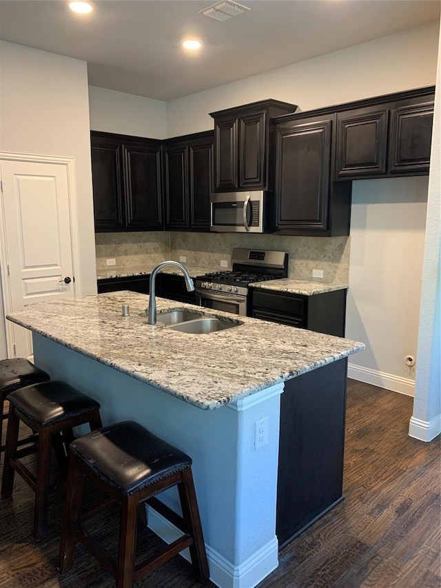 1609 Emerald Tree Pl, Aubrey, TX 76227 - kitchen featuring stainless steel appliances, a sink, light stone countertops, a breakfast bar, and recessed lighting