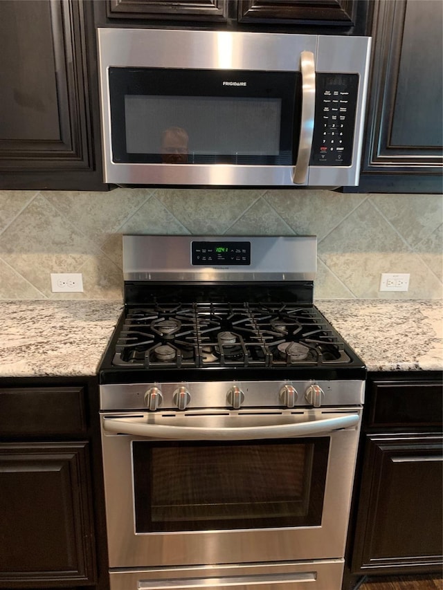 1609 Emerald Tree Pl, Aubrey, TX 76227 - kitchen with appliances with stainless steel finishes, tasteful backsplash, and dark brown cabinetry