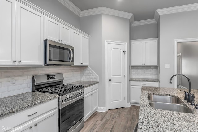 345 Coppice Pl, Bossier City, LA 71111 - kitchen featuring appliances with stainless steel finishes, a sink, crown molding, white cabinetry, and decorative backsplash