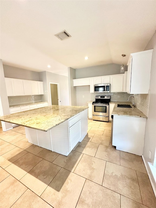 kitchen featuring appliances with stainless steel finishes, a sink, light stone counters, white cabinetry, and recessed lighting