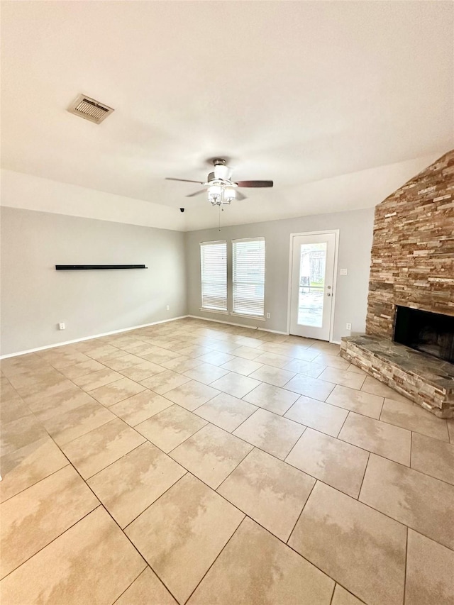 unfurnished living room with light tile patterned flooring, a ceiling fan, a fireplace, and baseboards