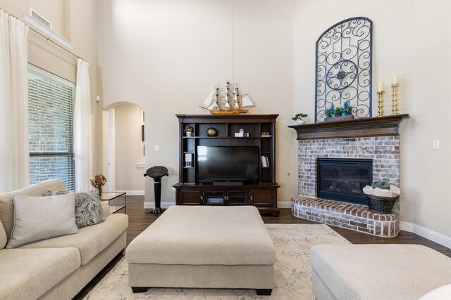 102 Autumn Sage Dr, Wylie, TX 75098 - living room with arched walkways, a high ceiling, wood finished floors, baseboards, and a fireplace