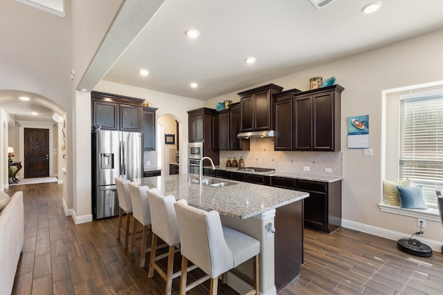 102 Autumn Sage Dr, Wylie, TX 75098 - kitchen featuring appliances with stainless steel finishes, arched walkways, a sink, dark brown cabinetry, and dark wood finished floors