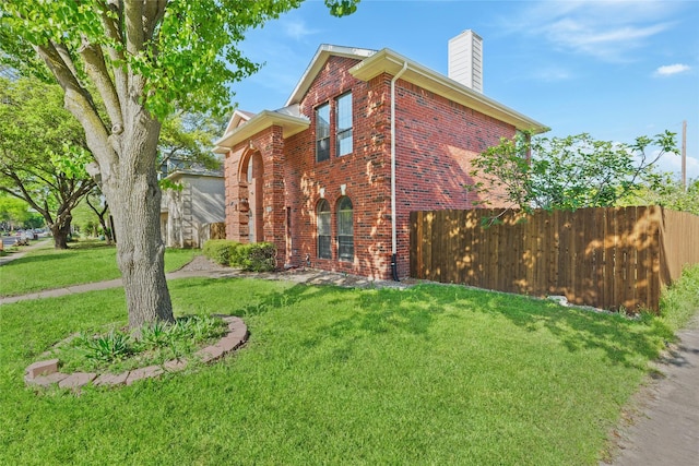 view of property exterior with brick siding, a chimney, and a lawn