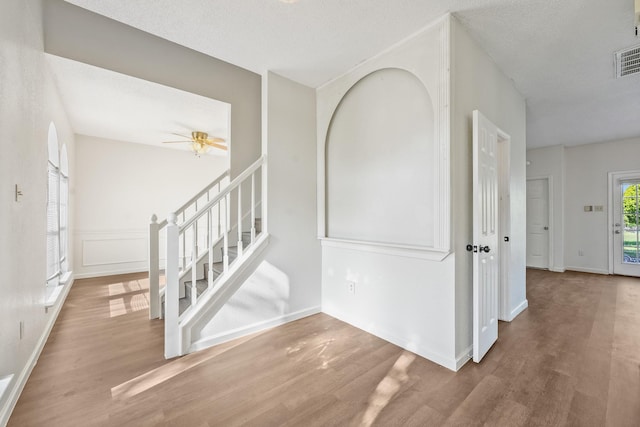 entrance foyer with wood finished floors, stairway, ceiling fan, and baseboards