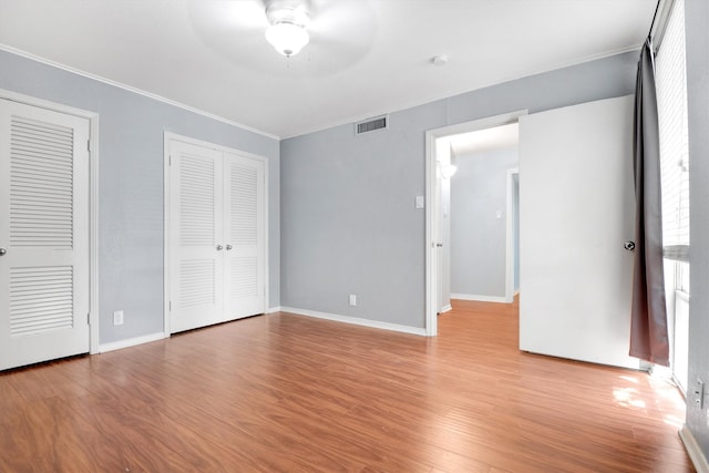 534 E Ave J Unit A, Grand Prairie, TX 75050 - unfurnished bedroom featuring light wood-type flooring, crown molding, multiple closets, baseboards, and a ceiling fan