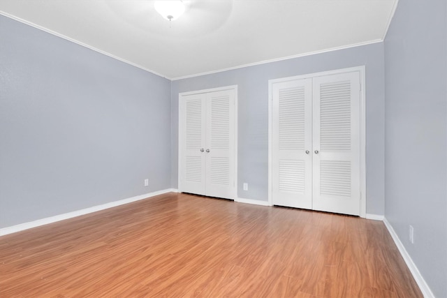 534 E Ave J Unit A, Grand Prairie, TX 75050 - unfurnished bedroom featuring two closets, ornamental molding, wood finished floors, and baseboards
