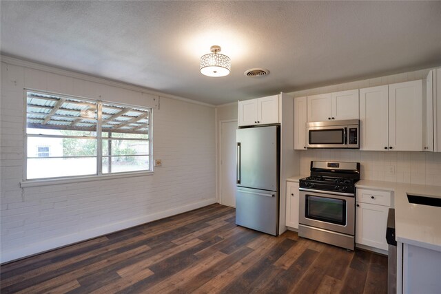 8113 Tumbleweed Trl, White Settlement, TX 76108 - kitchen featuring appliances with stainless steel finishes, light countertops, white cabinetry, brick wall, and dark wood-type flooring