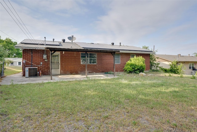 8113 Tumbleweed Trl, White Settlement, TX 76108 - back of property with a patio, a yard, brick siding, solar panels, and central AC